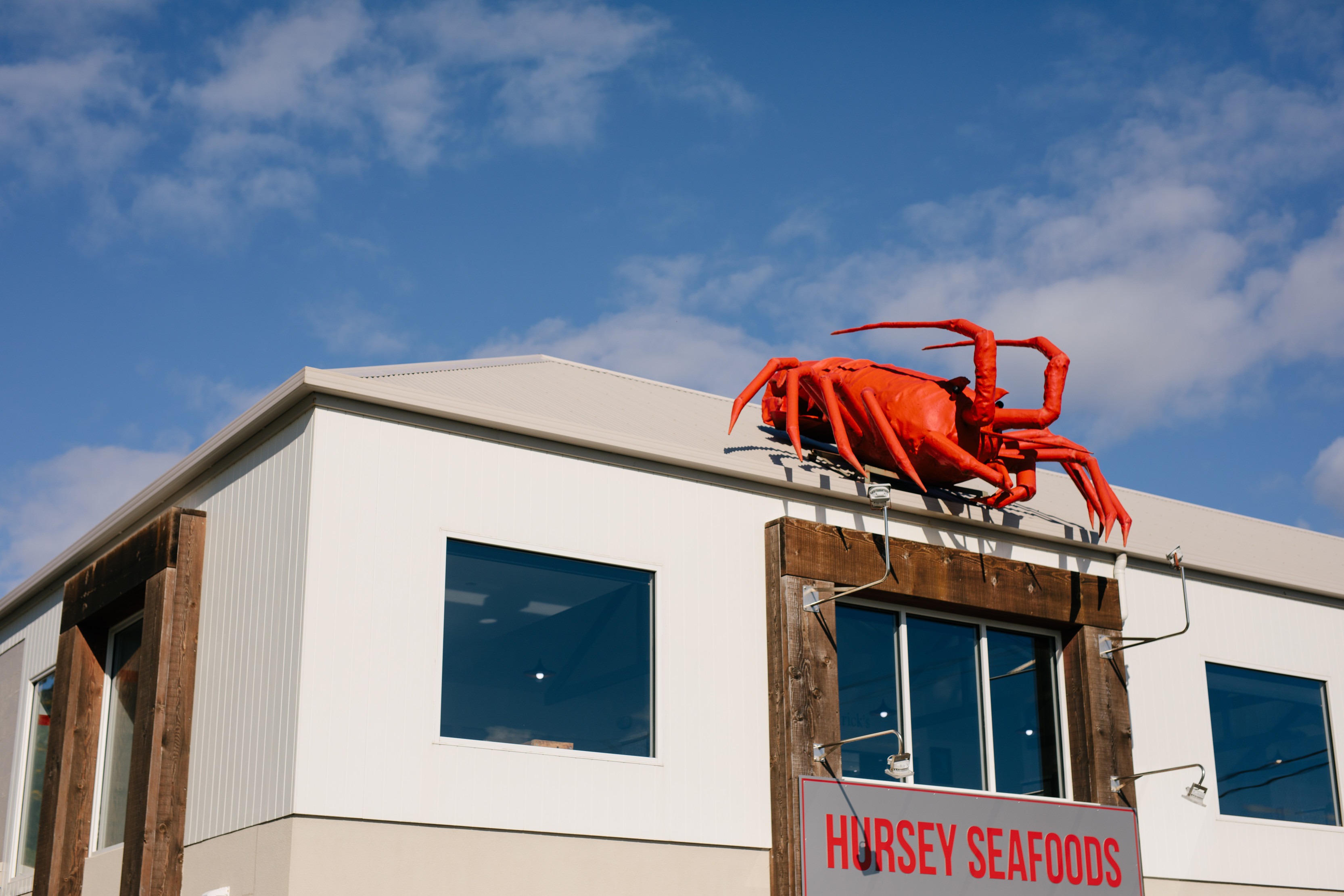 A large, manmade lobster sits on the top front of Hursey Seafoods.