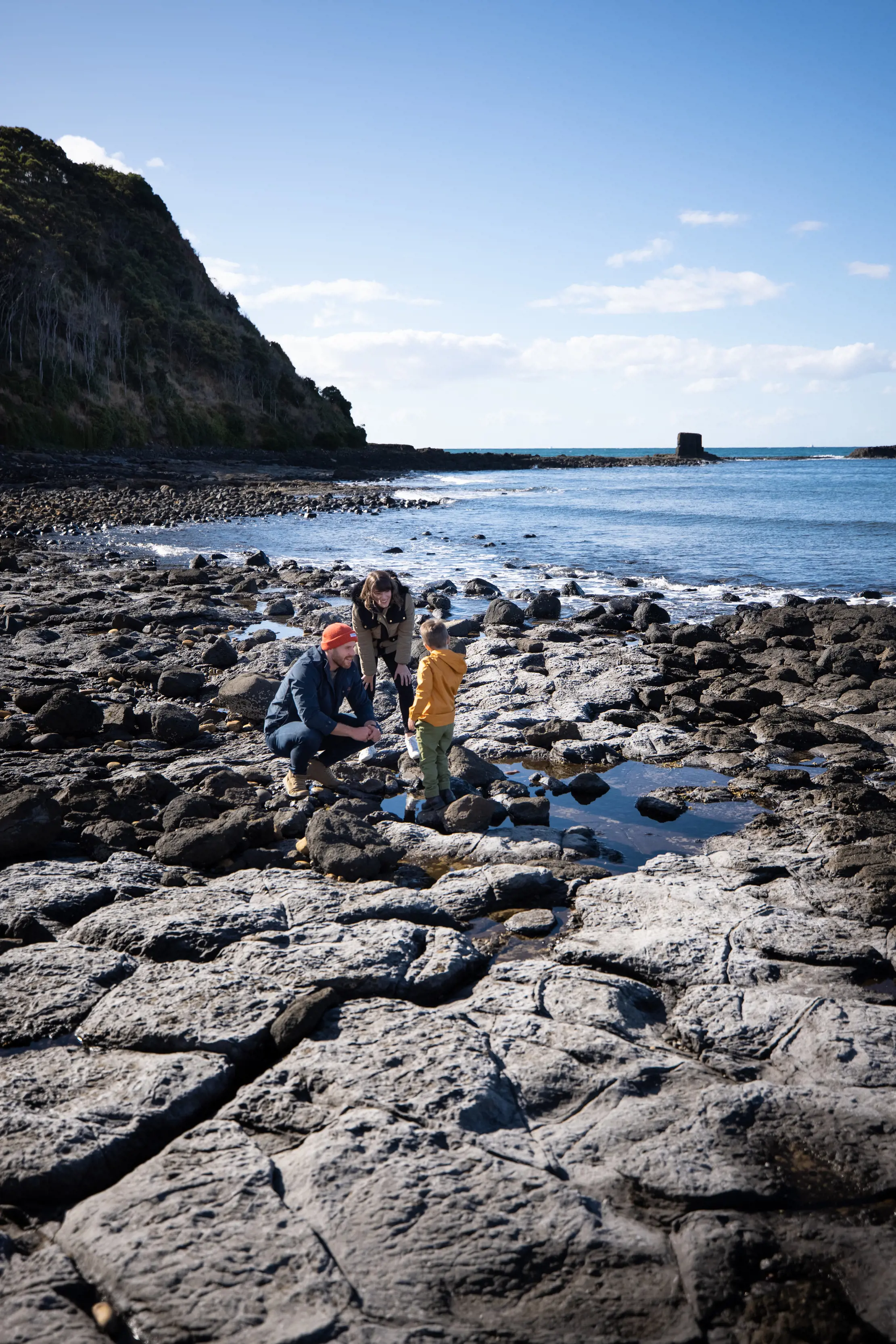 Image of Father, Mother and Son together on the rocky coast of Don Heads, Don reserve on a clear, sunny day.