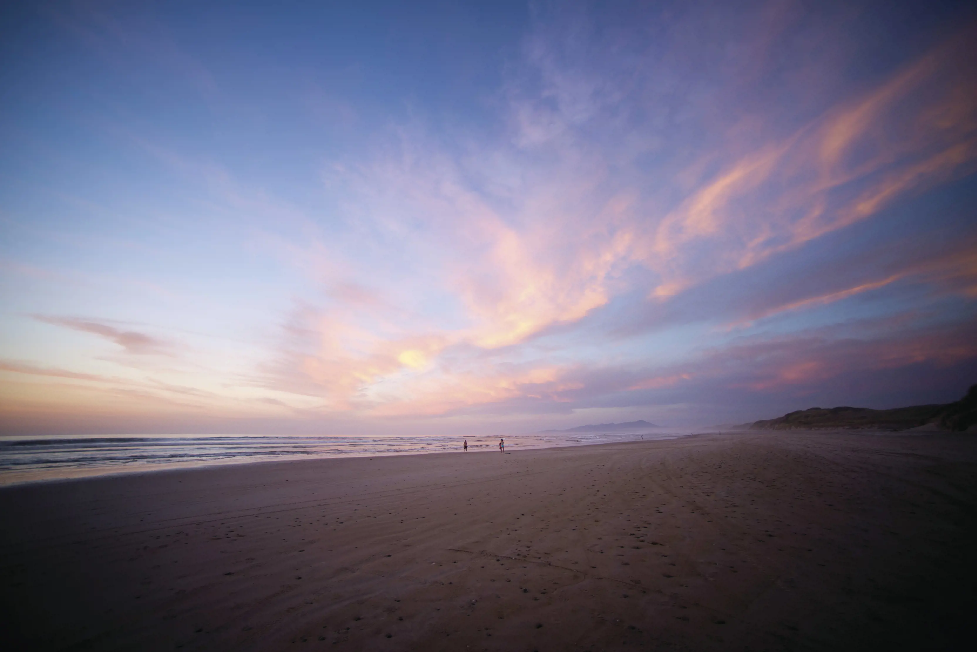 Sunset at Oceans Beach painting the clouds orange, yellow and pink.