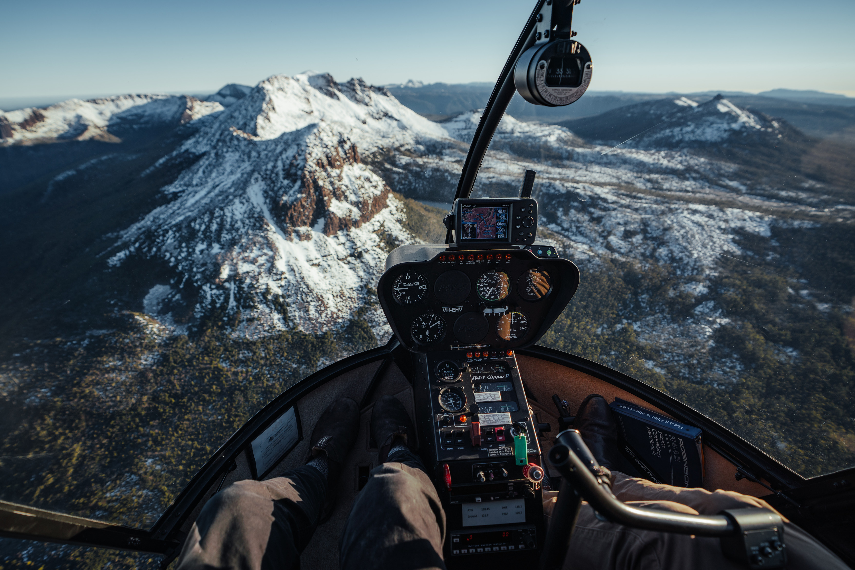 Jaw-dropping point of view image taken in a helicopter, overlooking the landscape of Mt Ossa and its surroundings, as part of Par Avion Wilderness Tours.