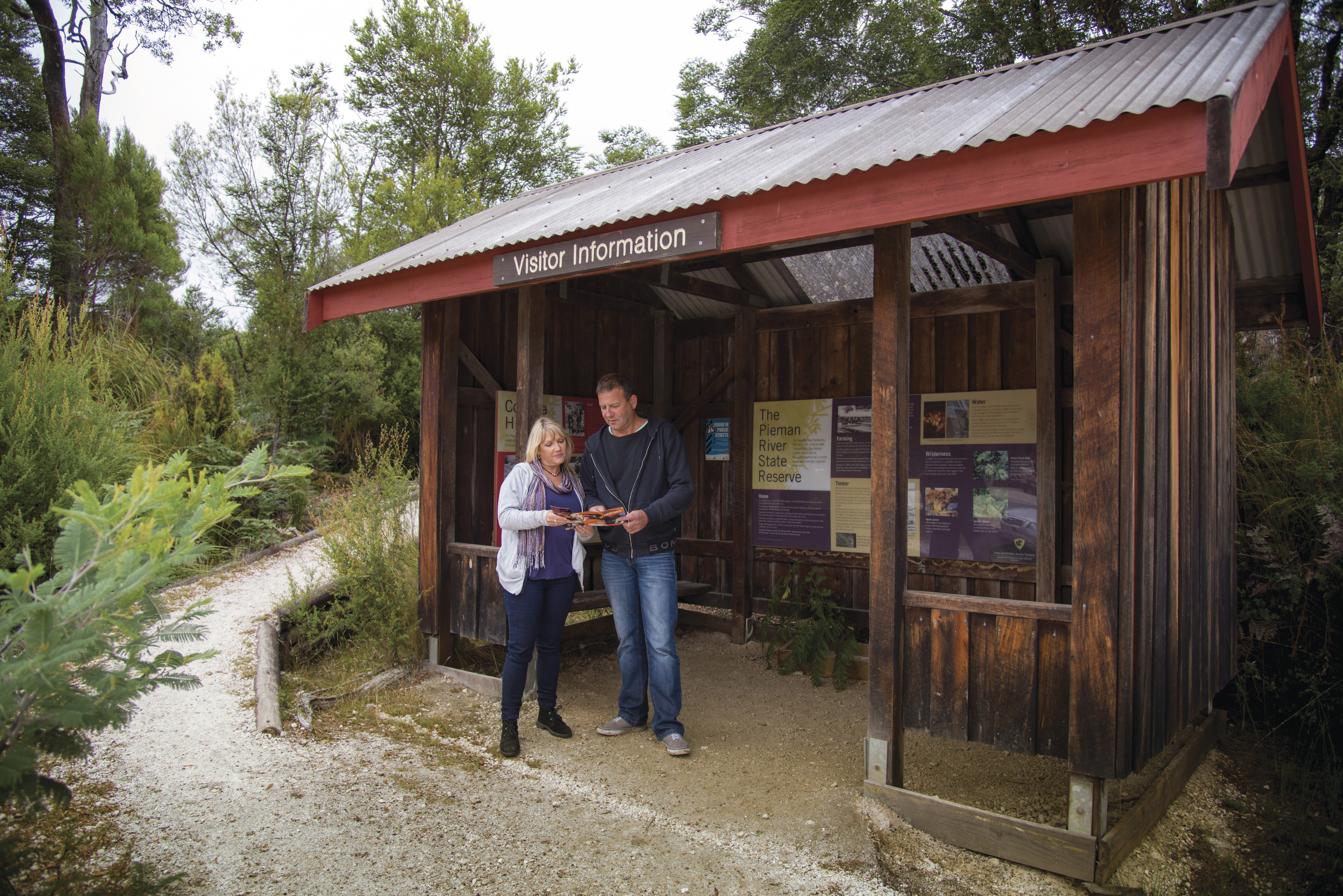 A couple stand outside the visitor infomation hut at Pieman River State Reserve.