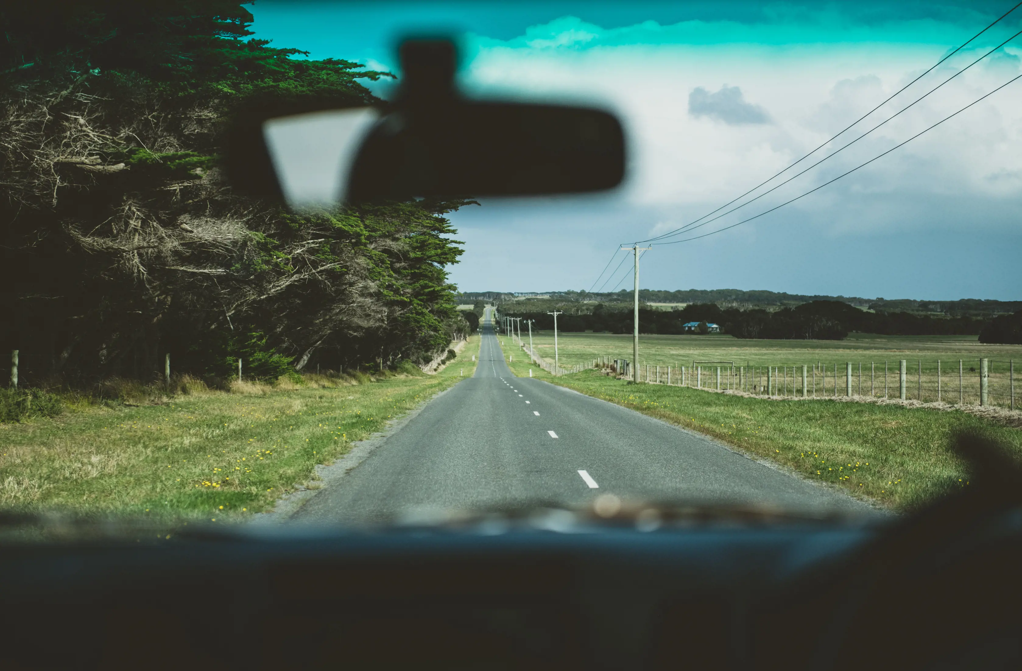 View from inside the front seat of a car. Rearview mirror fuzzy in te shot. Driving to Martha Lavina Beach, Kind Island. 