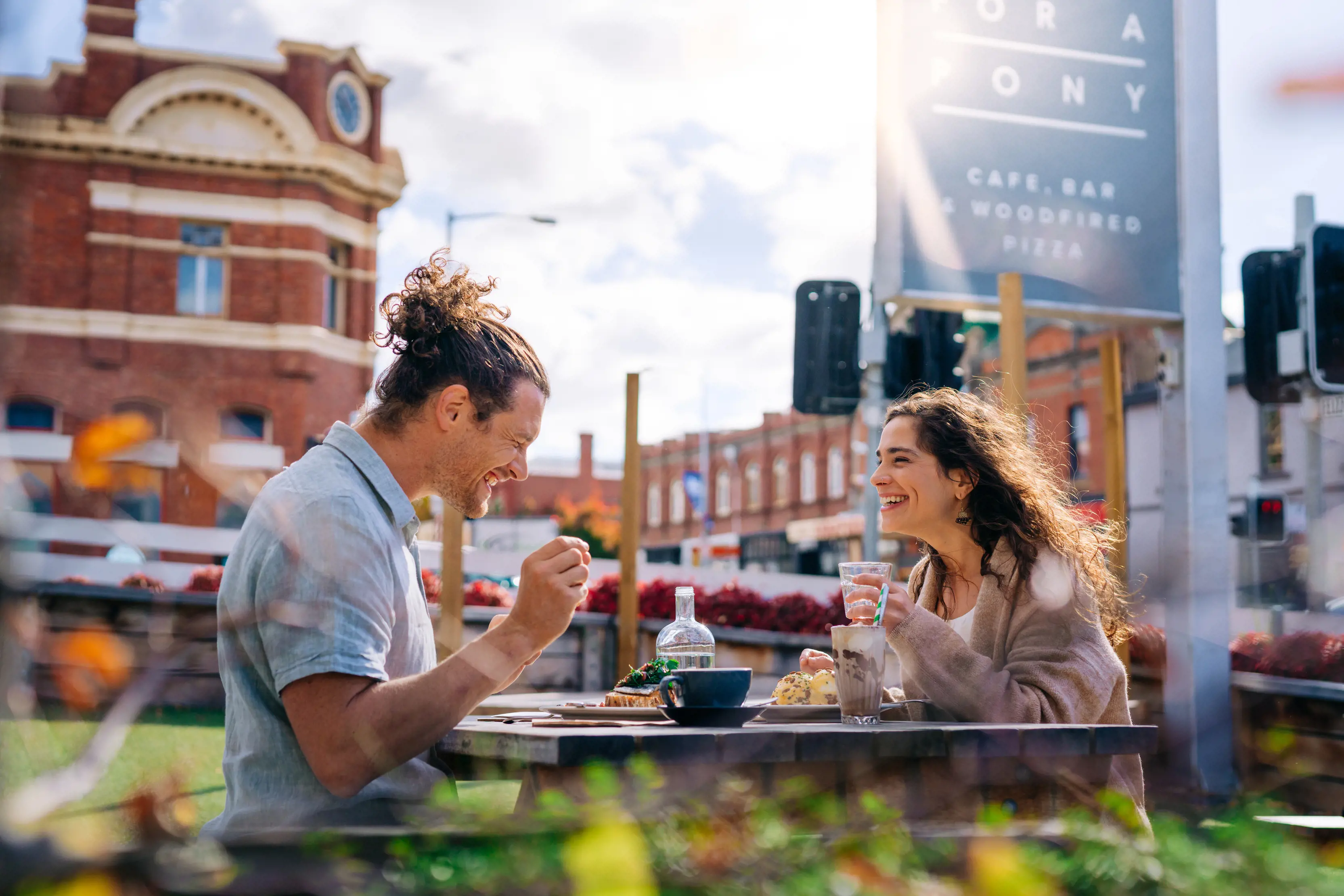 A couple enjoy food and coffee sat outside at Room for a Pony cafe and bar in Hobart.