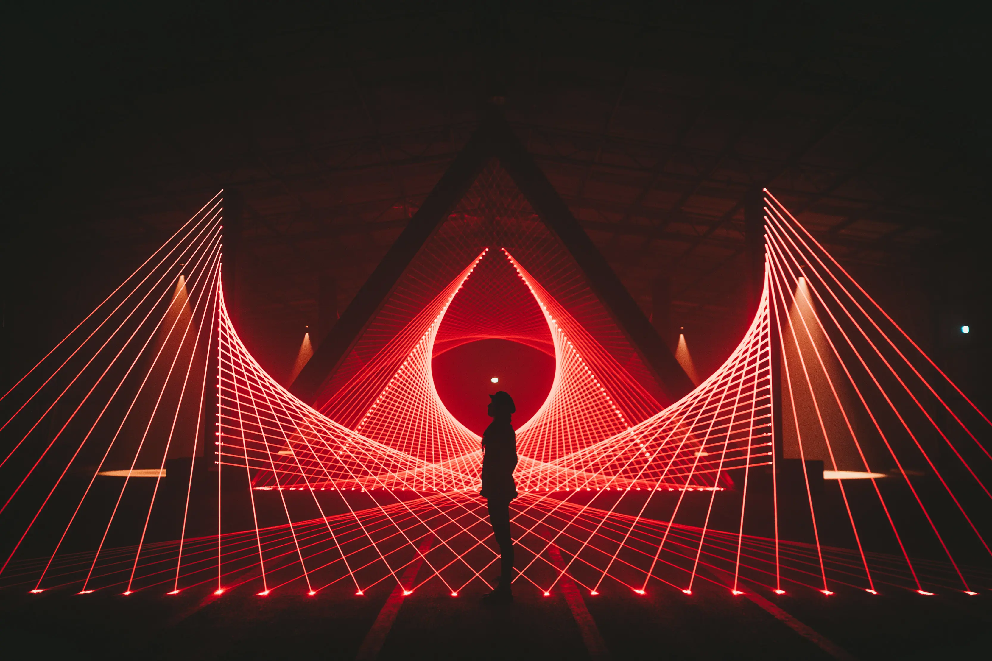 A single person standing amongst a laser light show at Dark Mofo winter festival