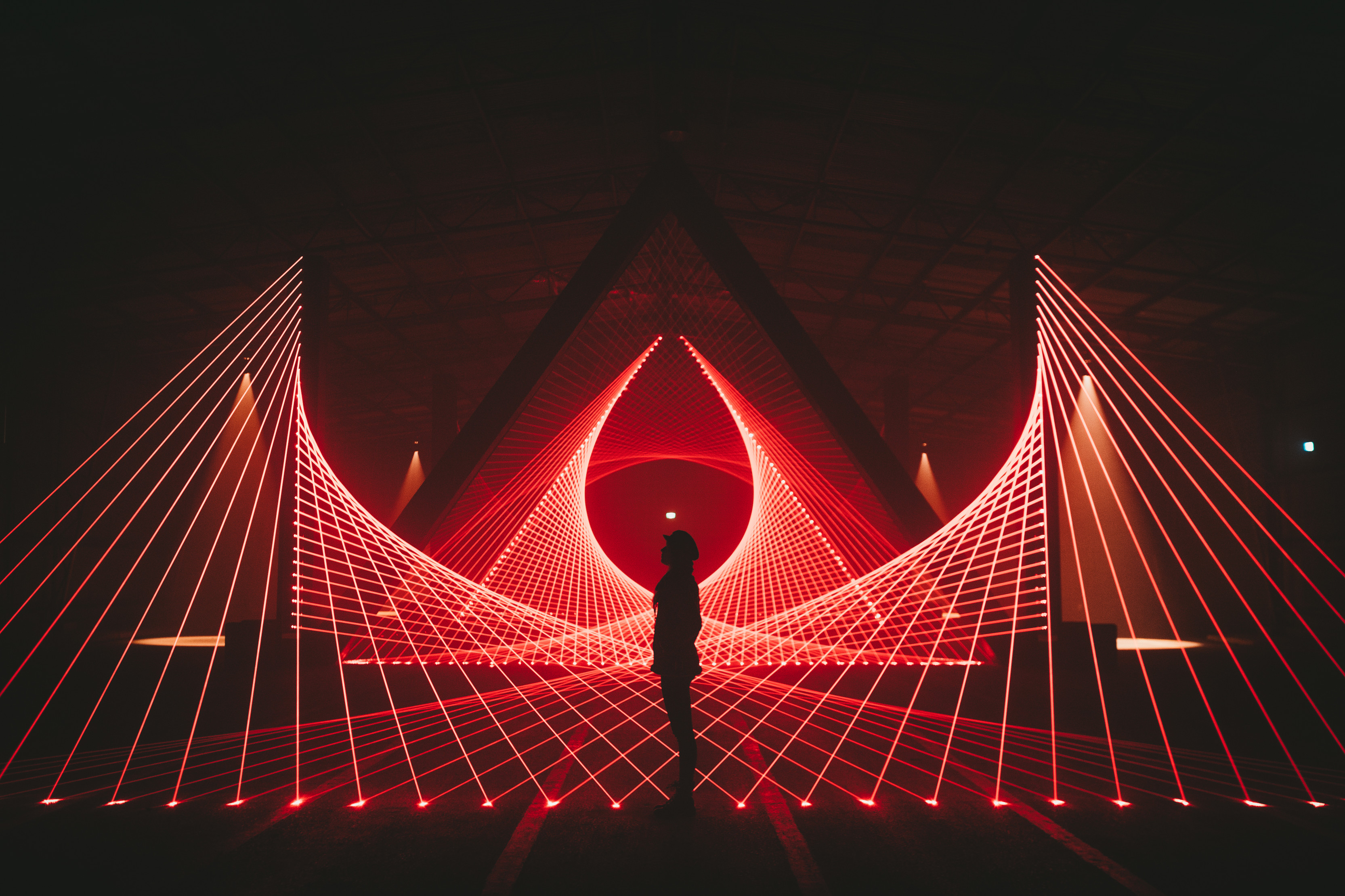 A single person standing amongst a laser light show at Dark Mofo winter festival