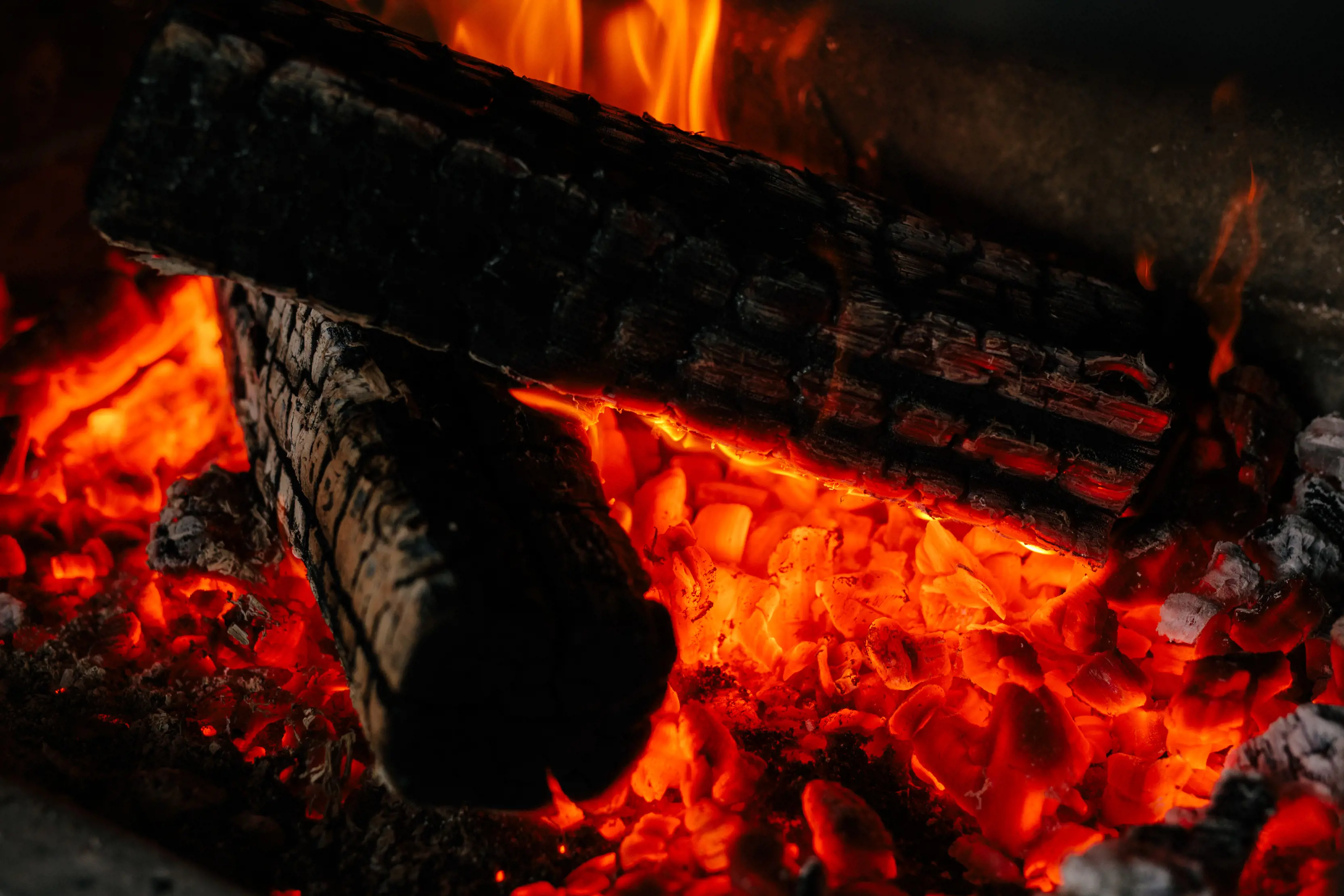 The glowing embers of a log stoked fire.