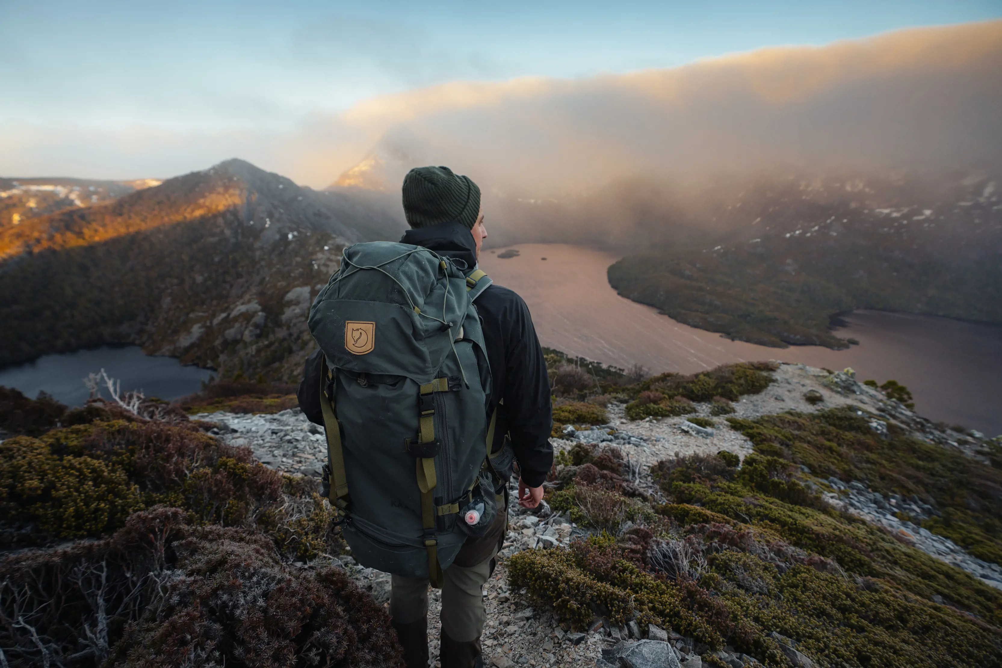 Breathtaking and vibrant image of person on top of the mountain, hiking around cradle Mountain-Lake St Clair National Park.