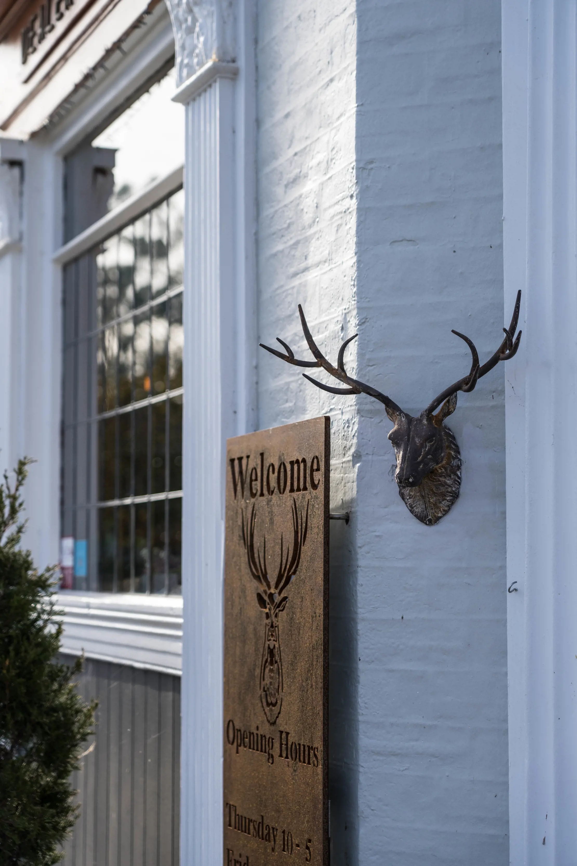 Image of a welcome and a man made deer head, placed out the front of the Clarendon Arms.