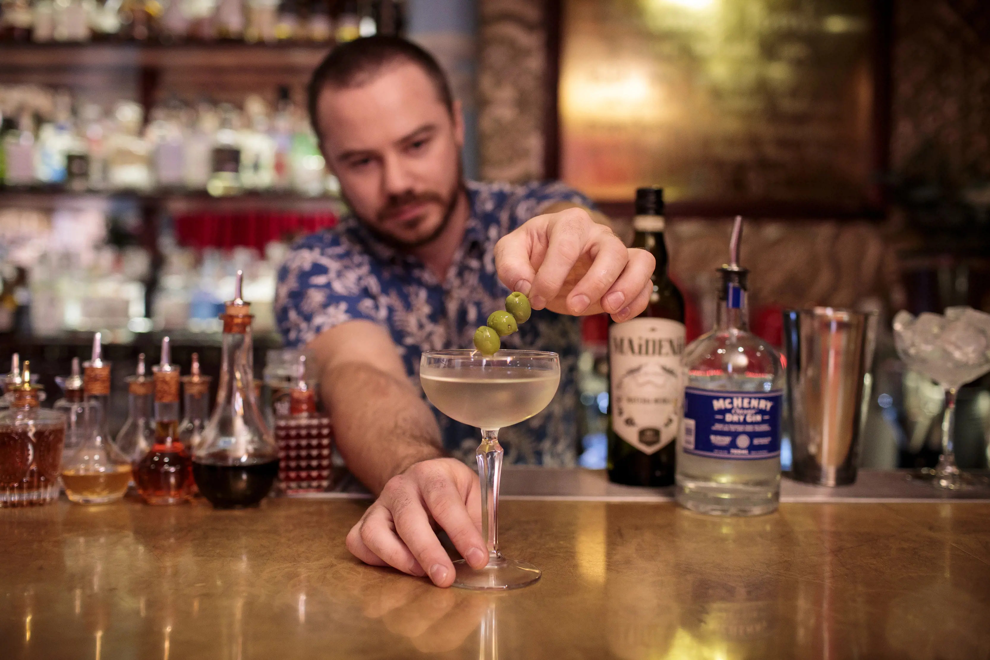 Image inside the Gold Bar, A cozy speakeasy bar with a man serving a specialty Tasmania cocktail.