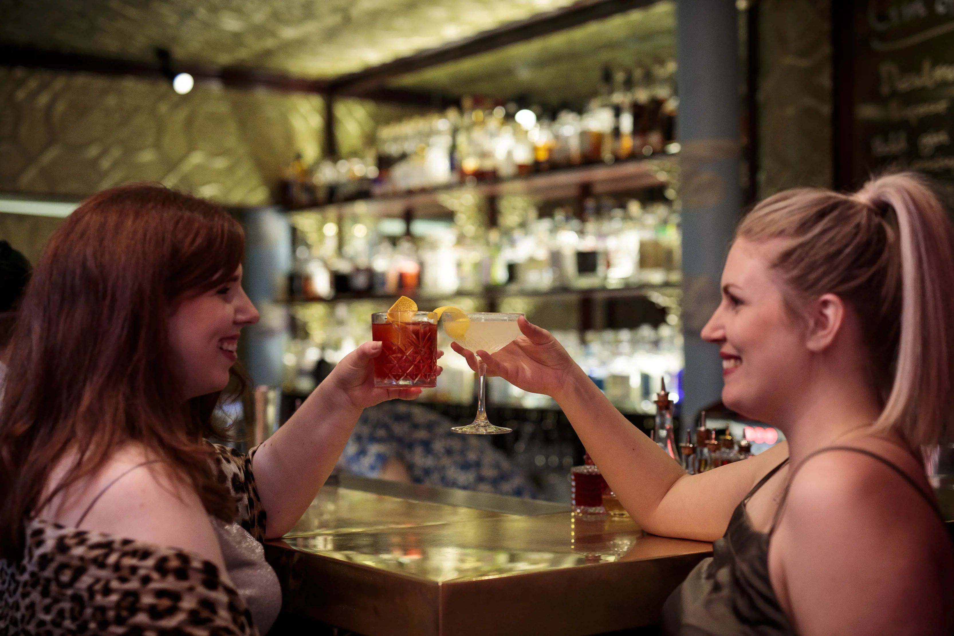 Two girls raising a toast with cocktails at the Gold Bar, Hobart.