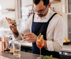 A man pours gin to make a cocktail at the Agrarian Kitchen.