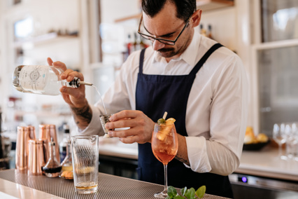 A man pours gin to make a cocktail at the Agrarian Kitchen.