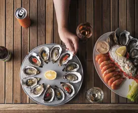 A platter of fresh oysters and other seafood presented on a platter.