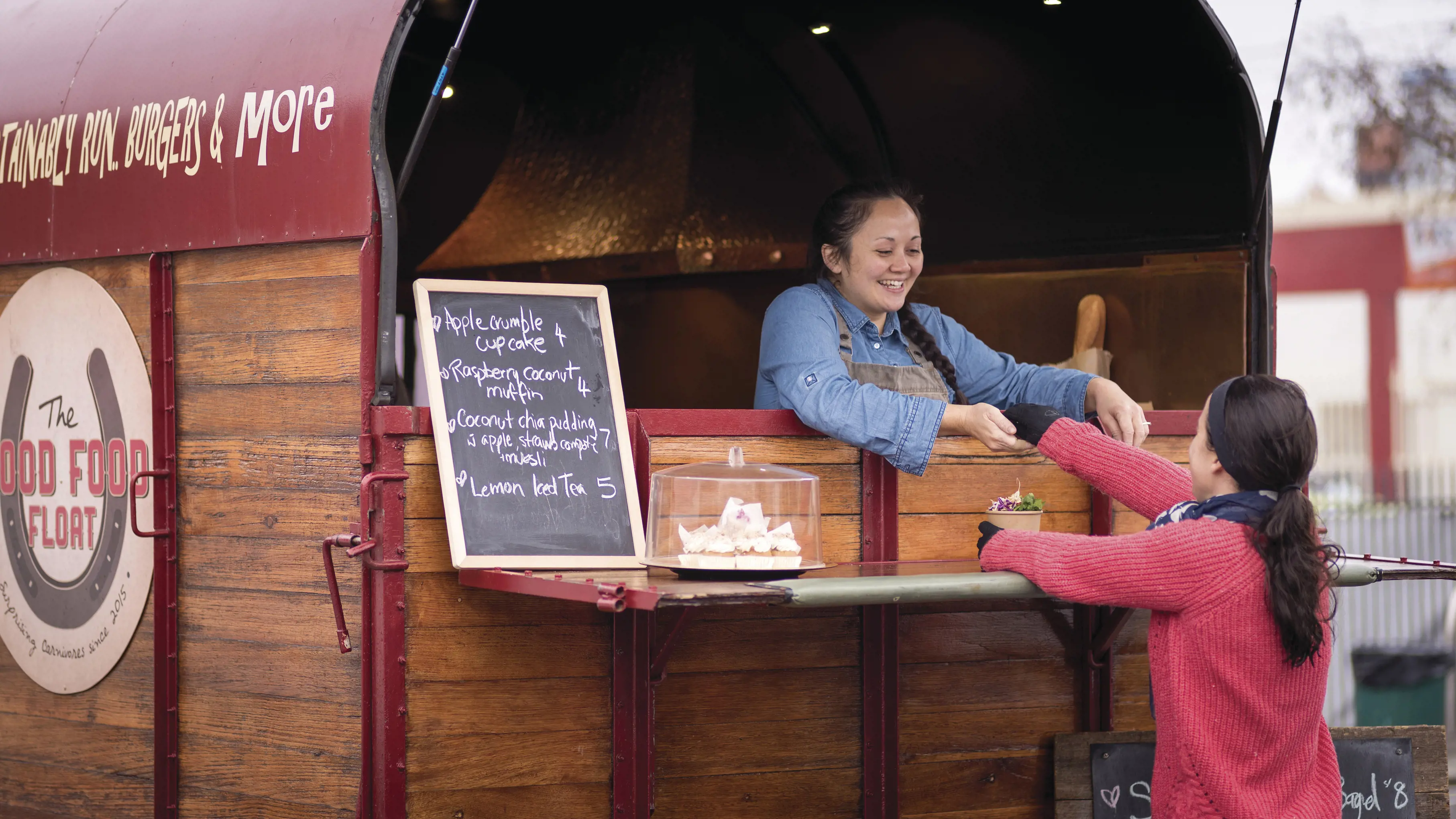 Customer purchasing food at the Harvest Launceston Farmers' Market - The Good Food Float.