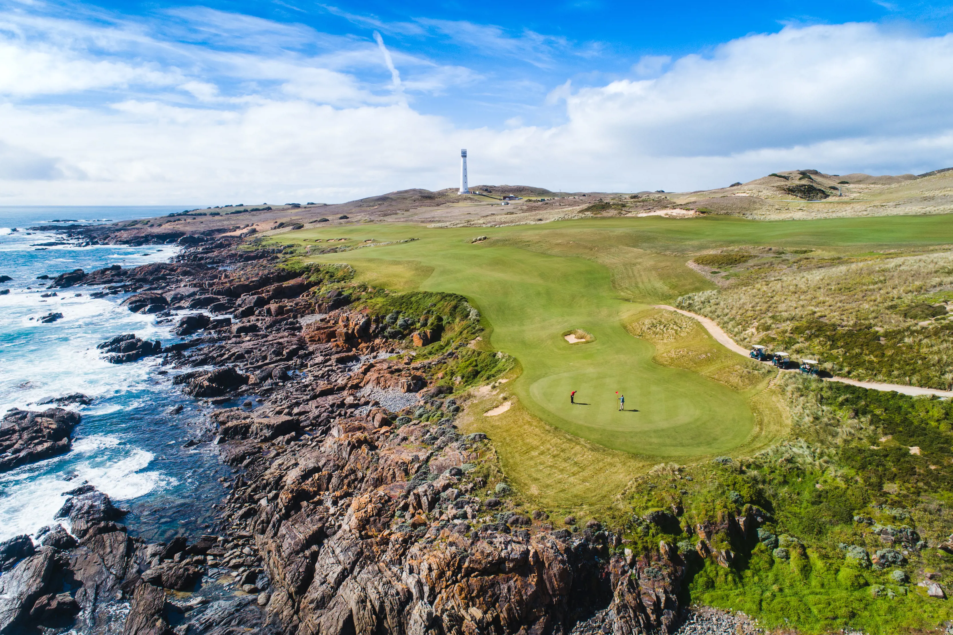 Wide aerial  shot of Cape Wickham Golf Course on King Island, with two golfers looking small in the distance.