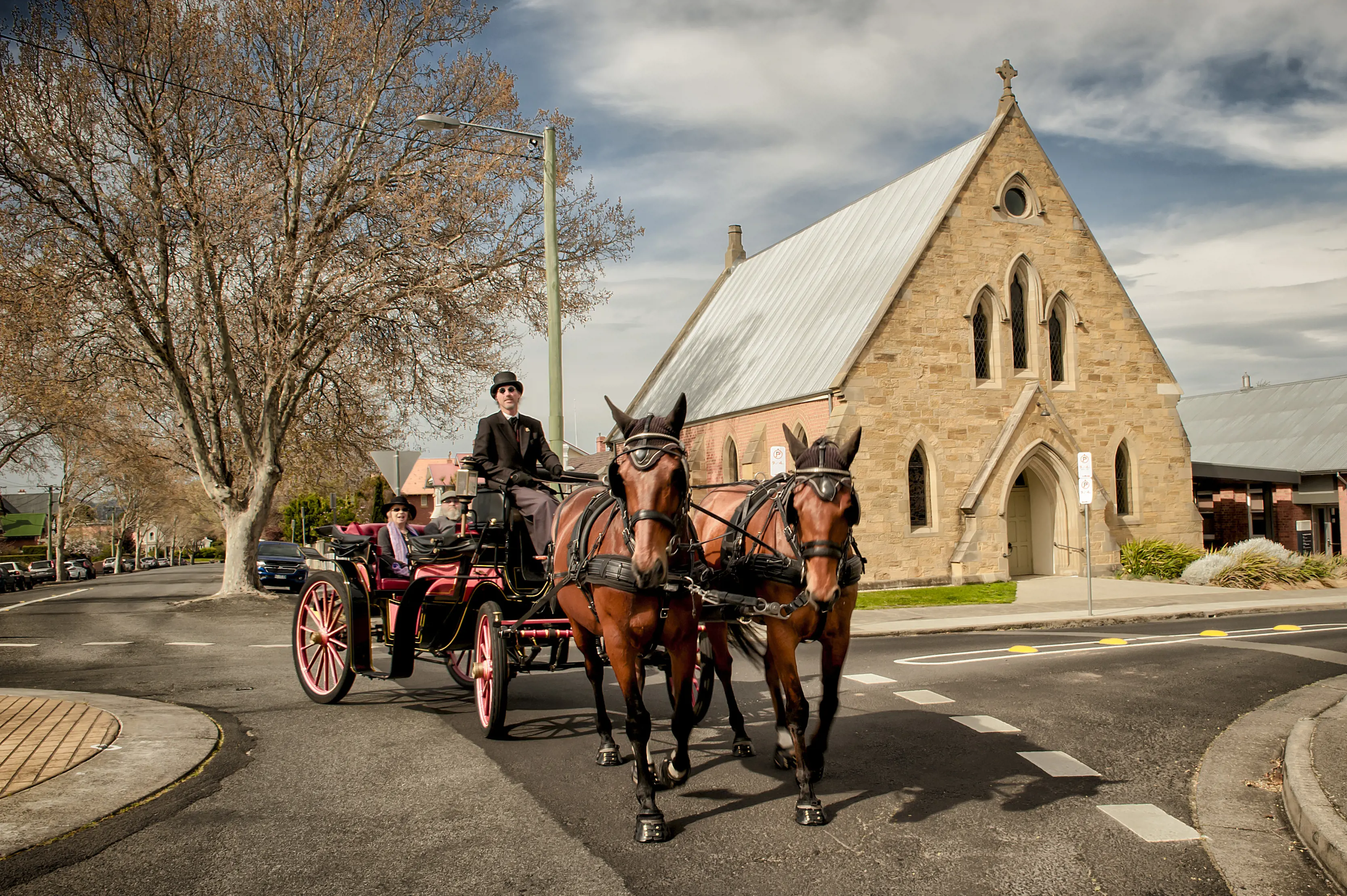 Two people experience Colonial Hobart by touring the Battery Point area and Salamanca Place, riding in an open carriage driven by a pair of horses.