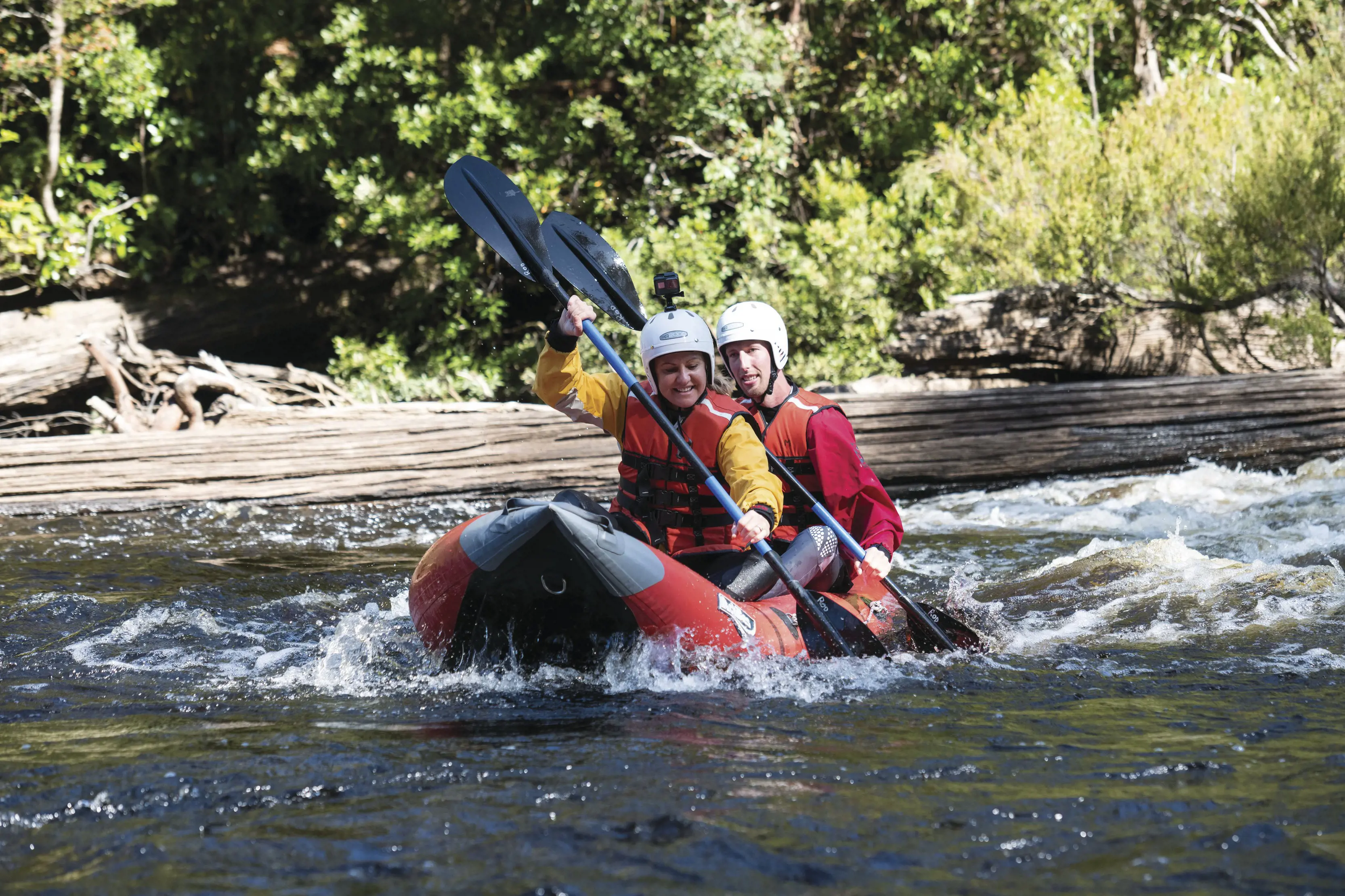 Couple paddling with their oars on a raft with Twin Rivers Adventure - Tahune Adventures.