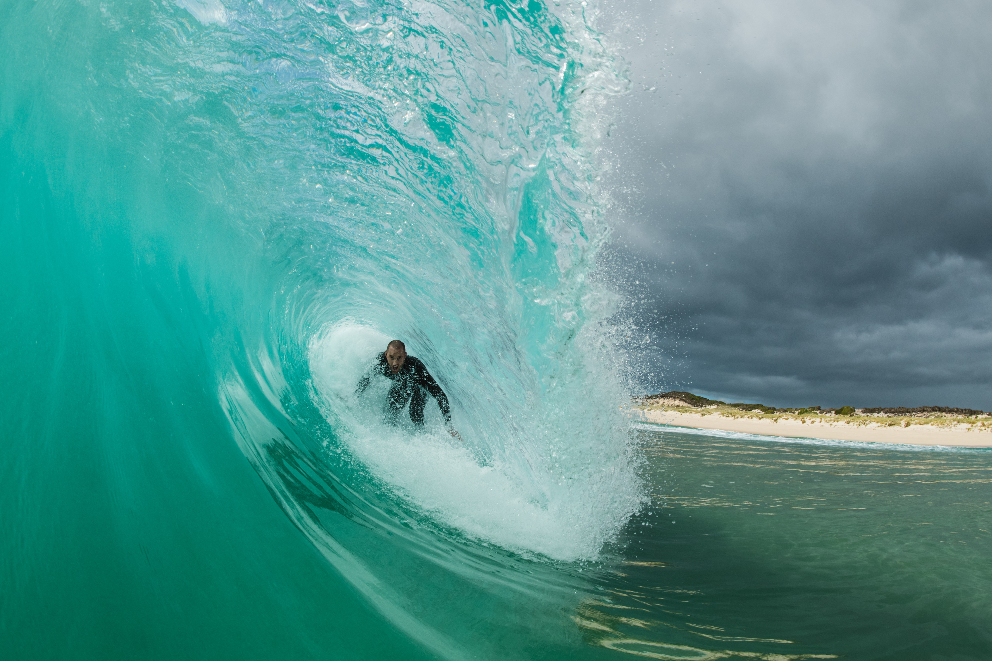 Incredible image of a person in crystal blue hollow wave at Martha Lavinia Beach, King Island.