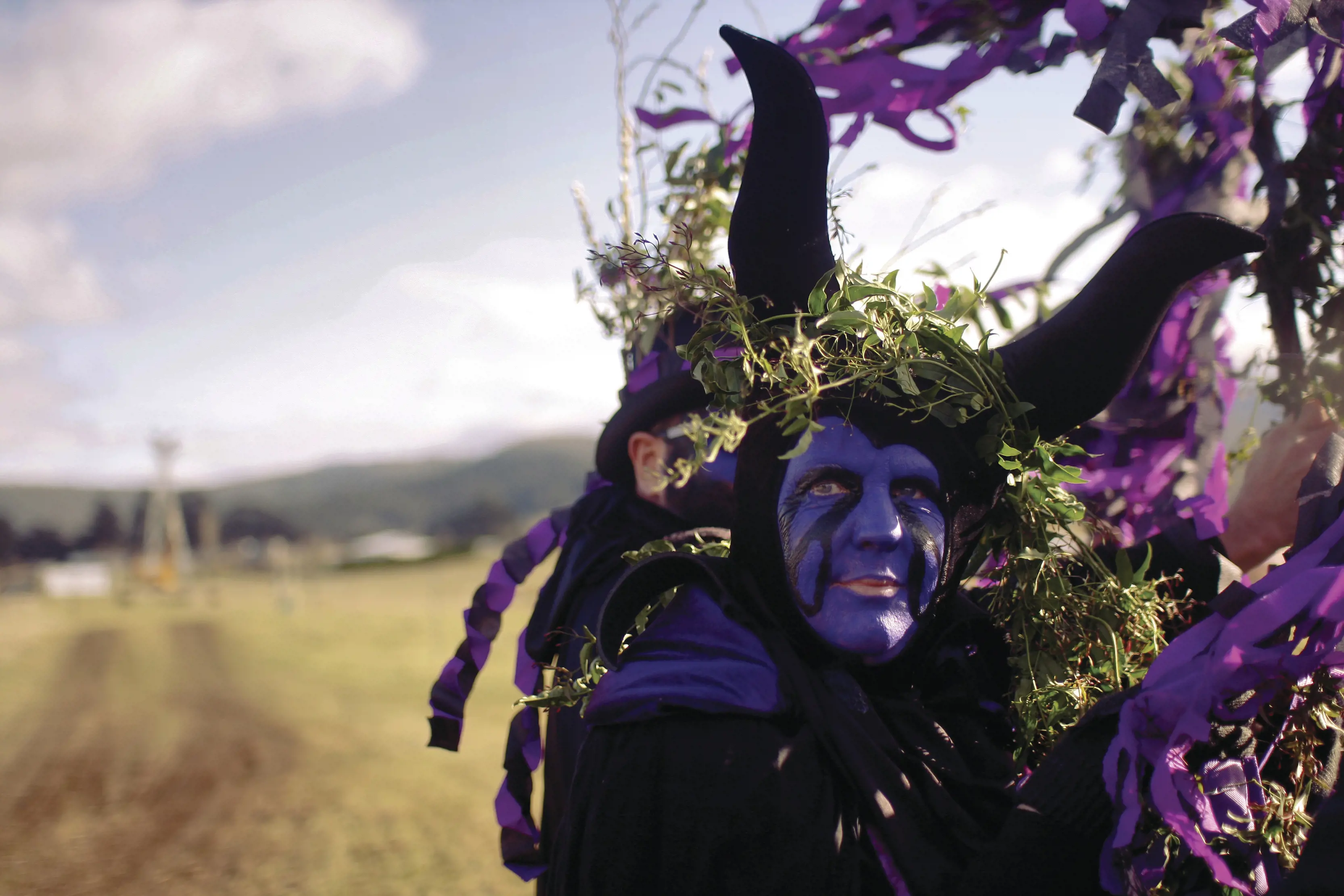 Person dressed up in purple and green for Huon Valley Mid-Winter Fest.