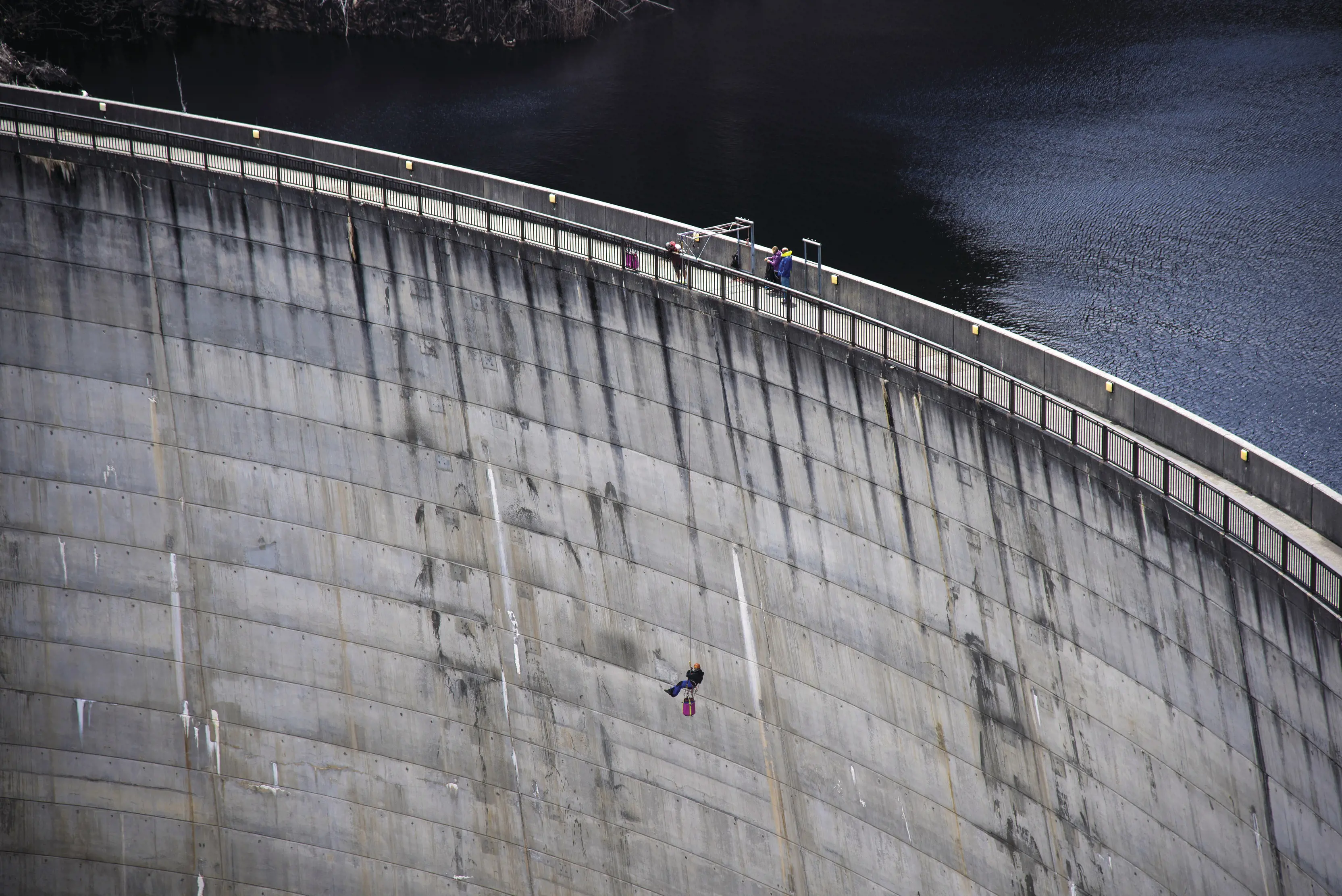 Jaw Dropping aerial image of a person abseiling down Gordon Dam - Aardvark Adventures.