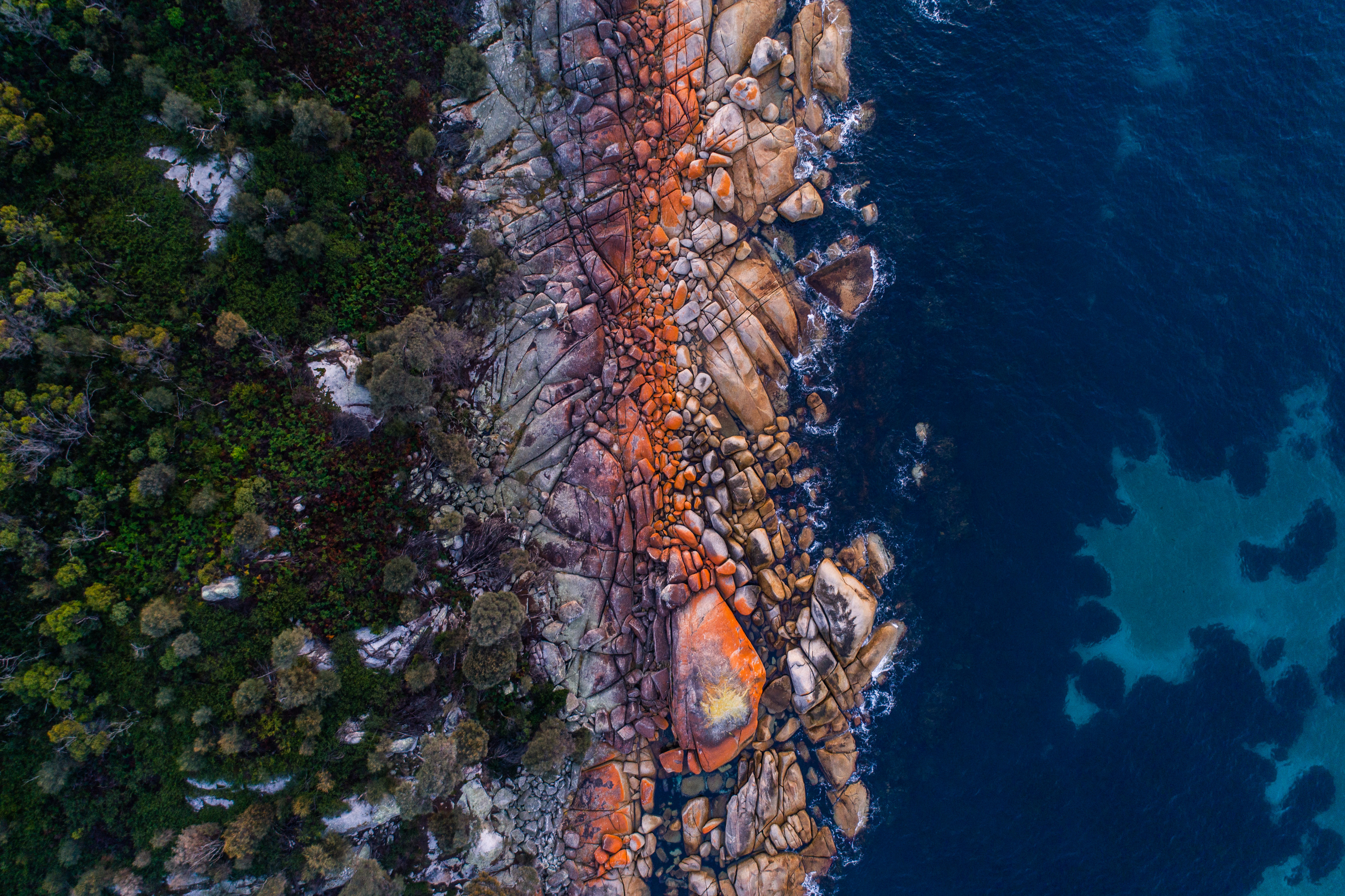 Jaw Dropping, vibrant aerial image over the Bay of Fires. Striking mix of colours from the bushland, and orange rocks, to the pristine ocean.