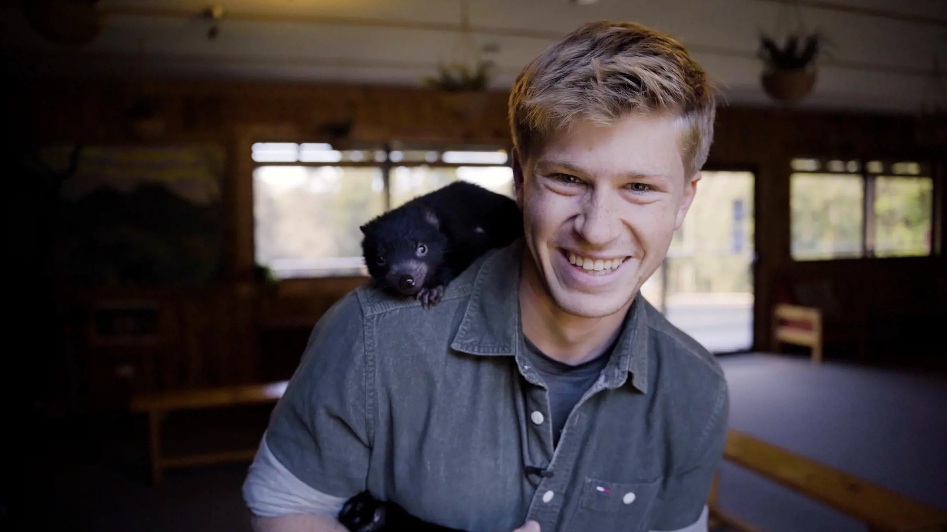 Robert Irwin with a Tasmanian devil on his shoulder at Devils @ Cradle